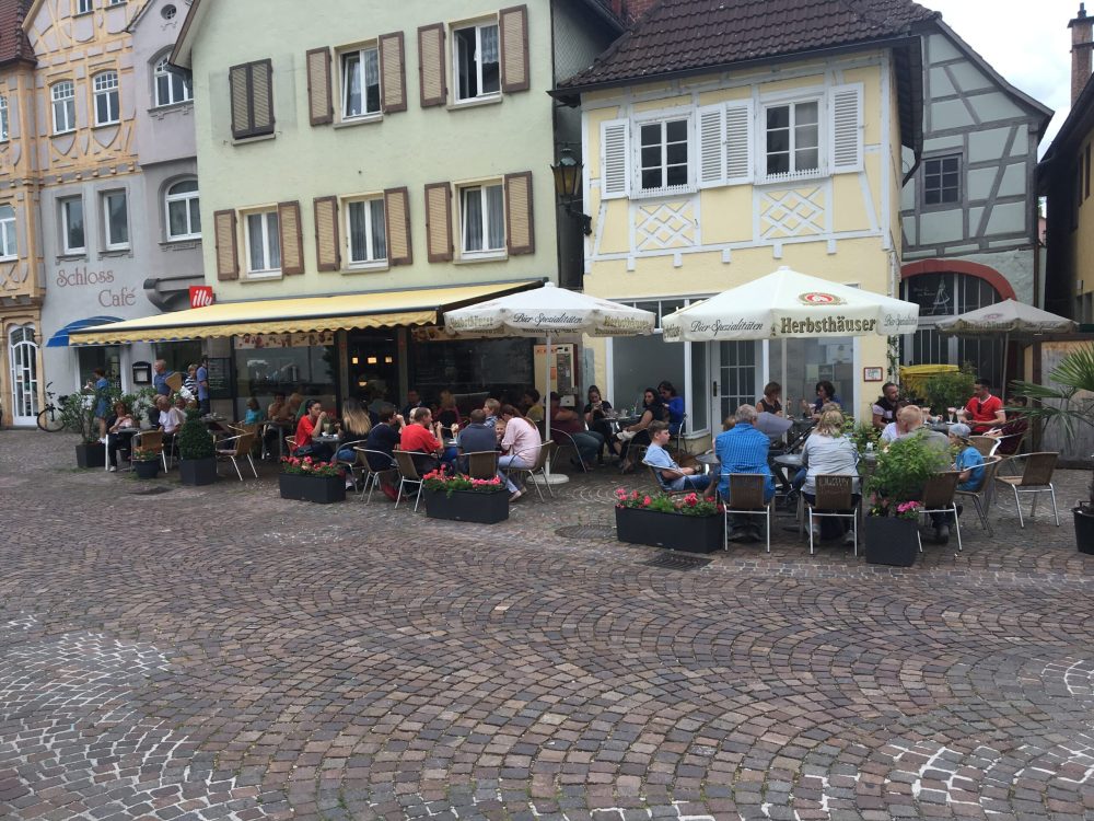 People dining at an outdoor café in a charming German town.